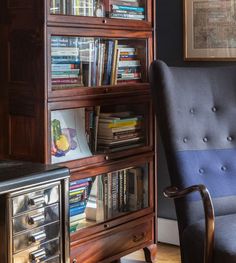 a chair sitting in front of a book shelf filled with books