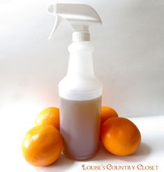 oranges and a spray bottle on a white surface