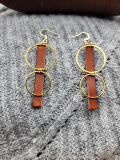 Genuine full-grain leather, laser cut rectangle shape earrings with gold colored stainless steel circles. Attached to 14k gold earring hooks. Approximately 2.5" by 1" Handmade  from the highest quality Horween leather from one of the oldest American tanneries, handcrafted to a luxurious finish. Gold Leather Dangle Earrings, Handmade Minimalist Leather Earrings, Minimalist Rectangular Leather Jewelry, Modern Brown Leather Earrings, Gold Leather Earrings For Gift, Brown Leather Minimalist Earrings, Minimalist Brown Leather Earrings, Everyday Gold Jewelry With Leather Strap, Everyday Brown Faux Leather Jewelry