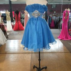 Short Strapless Dress With Ruffle Bodest And Tull Belt With A Cluster Of Gems, And A Puffy Tull Skirt Blue Knee-length Mini Dress For Prom, Blue Knee-length Homecoming Mini Dress, Blue Knee-length Mini Dress For Homecoming, Royal Blue Strapless Dress For Prom Season, Royal Blue Strapless Dress For Prom, Blue Strapless Dress For Homecoming Prom Season, Light Blue Strapless Dress For Prom Season, Light Blue Strapless Dress For Prom, Blue Strapless Dress For Prom