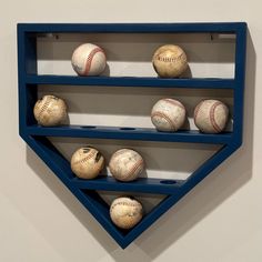 baseballs are lined up on shelves in the shape of a triangle