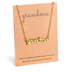 a gold necklace with the word grandma written in cursive font on it, sitting next to a card that says grandma