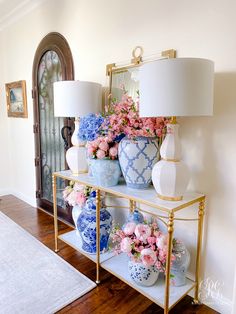 vases and flowers are sitting on a shelf in the entryway