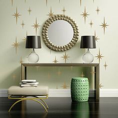 a table with two lamps and a mirror on it in front of a wall decorated with stars