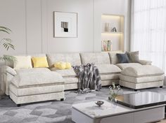 a living room filled with furniture and a large white sectional couch next to a coffee table