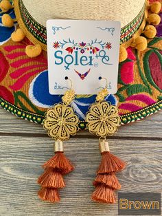 These Beautiful Mexican Earrings are made with the Mexican art form of twisting gold plated wires to create beautifully intricate works of art. The silk thread tassel adds that beautiful pop of color to any outfit. These earrings are handmade by Mexican Artisans. More colors available here: https://www.etsy.com/es/listing/974160414/aretes-mexicanos-de-filigrana-aretes?ref=listing_published_alert Mexican Earrings, Floral Filigree, Thread Earrings, Traditional Mexican, Mexican Dresses, Filigree Earrings, Mexican Art, Floral Earrings, Silk Thread