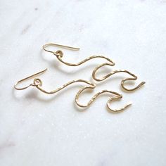 "These ocean inspired wave earrings come in either sterling silver or gold filled. They're shaped from 16g wire into a beautiful double wave and hammered for added texture. They measure approximately 2-2 1/2\" in length. Please allow for slight variations as each pair is unique." Gold Freeform Earrings As Gift, Gold Freeform Earrings For Gift, Beachy Earrings, Wave Earrings, Homemade Earrings, Earrings Double, Wave Bracelet, Ocean Inspired, Hammered Gold