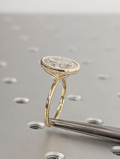 a diamond ring sitting on top of a piece of metal