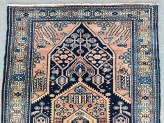 an antique rug with blue and pink colors