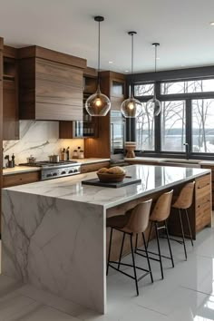 a large kitchen with marble counter tops and wooden cabinetry, along with bar stools