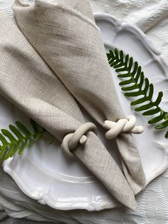 a white plate topped with two napkins covered in green leaves