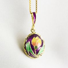 "Enameled and 24K gold plated sterling silver miniature egg pendant created in our NJ shop in the tradition of Faberge jewelry. Enamel is applied over solid sterling silver surface leaving uncovered only the engraved bezel of the egg and the contour of the tulips with leaves. Peridot color green crystal is set at the bottom of the flowers. I included other color versions of this pendant we make.  They may be available upon request.  This is a pretty small egg - about 0.45\" (12 mm ) without a bail. It comes ready to wear with 18\" sterling silver gold plated chain and in a gift box. If you feel that you need a longer chain, please, contact us, or request it during purchasing: we have 20\" chains in stock. Please keep in mind, that a chain is a free gift and is not included in the price of Red Flower Necklace, Tulip Necklace, Jewelry Enamel, Bouquet Jewelry, Faberge Jewelry, Purple Pendant, Green Pendants, Red Pendants, Tulip Flower