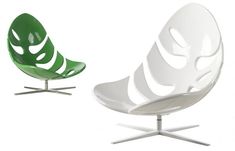 two modern chairs sitting side by side on top of each other, one green and the other white