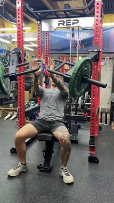 a man is squatting on a bench in the gym