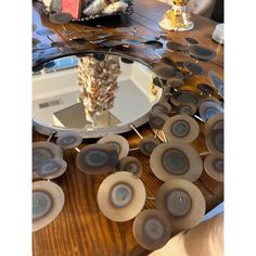 a round mirror sitting on top of a wooden table