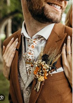 a man in a suit and tie with flowers on his lapel