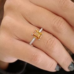 a woman's hand with a yellow and white diamond ring