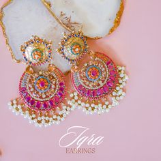 Adorn into the extravagant fusion of grace and royalty! Paint yourself in luscious shades of nauratan stones enhanced by pearl moti hanging with a classic embodiment of ravishing design radiating elegant femininity. Approximate earrings length is 4". Gold-plated on high-quality brass as base metal. In-stock & ready-to-ship. *Please Note: The multi-colored beadwork might be slightly varying in pattern. We use faux stones and beads in all of our jewelry. Festive Jeweled Chandbali Pearl Earrings, Elegant Multicolor Chandbali Chandelier Earrings, Fusion Style Jeweled Danglers For Diwali, Fusion Style Jeweled Bridal Earrings For Diwali, Elegant Multicolor Stone Work Chandbalis, Elegant Multicolor Chandbali Bridal Earrings, Fusion Jeweled Bridal Earrings For Diwali, Elegant Multicolor Chandbalis With Stone Work, Fusion Jeweled Danglers For Diwali