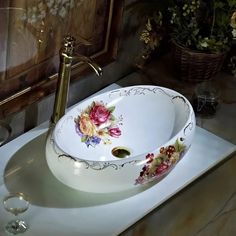 a white sink with flowers painted on it