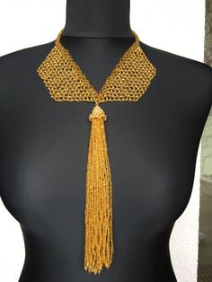 This unique gold tassel pendant necklace is a unique and luxurious piece of jewelry for any special occasion. It is made entirely of Czech beads, and in the hat of the tassel I have swapped several Swarovski crystals. The buckle is made is from the same beads . This is the perfect gift for yourself or a loved one who values uniqueness and class. Luxury Gold Beaded Necklace For Party, Party Tassel Dangle Necklaces, Party Necklaces With Tassels And Dangle Shape, Party Dangle Necklaces With Tassels, Elegant Gold Beaded Necklaces For Parties, Elegant Party Beaded Necklaces With Gold Beads, Elegant Party Gold Beaded Necklaces, Elegant Handmade Chain Necklace With Round Beads, Elegant Gold Bead Necklaces For Party