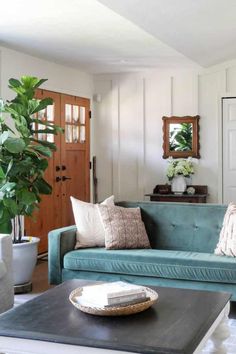 a living room with blue couches and pillows on the coffee table in front of a mirror