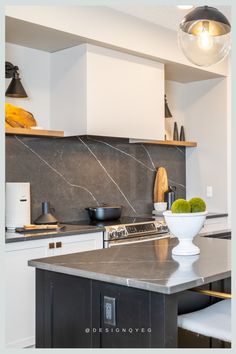 a kitchen with marble counter tops and an island in front of the stove top oven