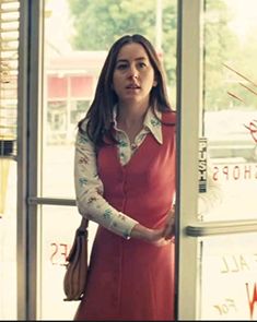 a woman standing in front of a store window