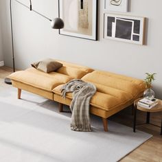 a living room with a couch, coffee table and pictures on the wall above it