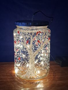 a lighted jar with a tree on it