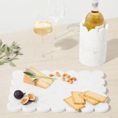 an assortment of cheeses, crackers and wine on a table