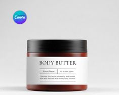 a jar of body butter sitting on top of a white table next to a black lid