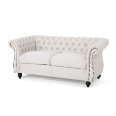 a white couch with black legs and buttons