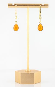 These lovely Carnelian Drop Earrings are a beautiful, bright and elegant addition to your jewelry collection. The vivid orange colored carnelian drops dangle from sparkling cubic zirconia and gold-plated ear wires. These earrings will make you smile, the color is so bright and beautiful and they easily transition from day to night! Beautiful, faceted orange carnelian vermeil bezels. Bright, gold plated ear wires adorned with a sparkling cubic zirconia stone. 1 inch long. Natural variations in th Orange Gemstone Drop Earrings, Orange Gemstone Dangle Earrings, Gold Carnelian Earrings With Ear Wire, Gold Carnelian Jewelry With Matching Earrings, Carnelian Gold Earrings With Ear Wire, Orange Teardrop Gemstone Earrings, Carnelian Amber Earrings For Gift, Amber Carnelian Gemstone Earrings, Amber Carnelian Earrings Gift