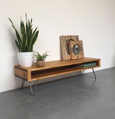 a potted plant sitting on top of a wooden shelf next to a white wall