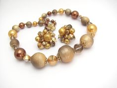 "Fabulous Vintage Vendome Necklace and matching clip on Earrings. Fall Holiday colors in tans and golds. Incredible sparkling crystals, faux pearls, and unusual beads at the front. Bold statement, and yet nice an lightweight to wear. Front center bead of necklace is 25mm in size. Flower hook clasp marked Vendome. Necklace is 18\" end to end. Earrings are about 1-1/4\" in size. Marked Vendome on the clips. Very very good, almost Excellent clean condition. Any questions, please ask. This is a fami Heirloom Jewelry, Unisex Earrings, Earrings Fall, Floating Necklace, Heirlooms Jewelry, Gold Heart Necklace, Holiday Colors, Cz Earrings