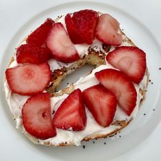 a white plate topped with a cake covered in strawberries