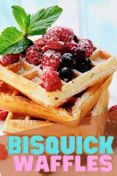 a stack of waffles topped with berries and mint