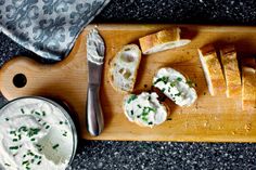 a cutting board topped with bread and cream cheese