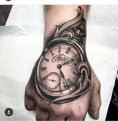 a man's hand with a clock tattoo on it