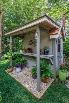 a small shed with potted plants on the outside and a bicycle in the back