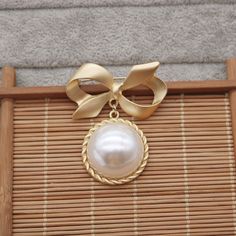 Show off your edgy style with this Gold Bow Brooch! With its eye-catching gold-plated design, intricate Vingate pattern, and sparkling pearl centerpiece, this large brooch is sure to make an impact. An ideal gift for her, this stylishly bold piece is perfect for adding a touch of glamour to any outfit. Ready to turn heads?👌 M A T E R I A L• 18K Gold plated over brass• Faux Pearl• This product is hypoallergenic (nickel free) and tarnish resistant📏 S I Z E• Length: 5.5 cm• Width: 4.5 cm Chic Gold Brooches For Party, Gold Brooch Pins For Party, Gold Wedding Brooches Chic Style, Gold Wedding Brooches In Chic Style, Chic Gold Wedding Brooch, Gold Chic Wedding Brooches, Chic Gold Wedding Brooches, Gold Pearl Brooches For Party, Pearl Centerpiece