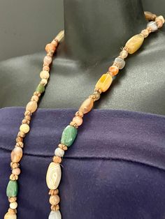 "Wonderful vintage gemstones necklace. With mixed shapes and sizes, this necklace is made with highly polished semi-precious hard stones, and punctuated by little woolen spheres bound with metallic thread. I see citrine, moonstone, agate, jade, and others. Some slight wear to the metallic threads. Stringing is excellent. It measures 36\" and weighs 3.7 oz. Most of our pieces are pre-loved vintage or antique items. They will sometimes have some wear as they are at least 20 years old. Please exami