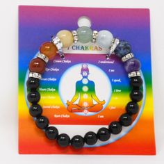 the chakras bracelet with seven chakras on it in front of a rainbow background