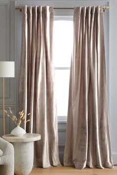 a living room with a large window covered in curtains