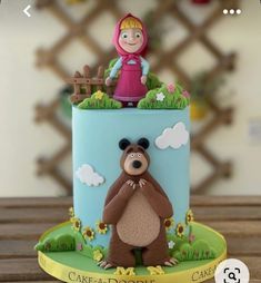 a cake with a bear and girl on top