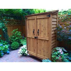 a wooden storage shed in the middle of a garden