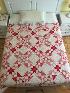 a bed with a red and white quilt on it