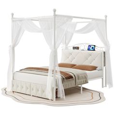 a white canopy bed sitting on top of a rug