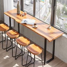 three wooden stools sit at the edge of a table with a book on it