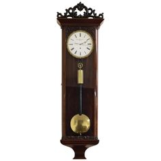 a clock with a pendulum on the side of it's face and an ornate design